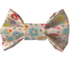 Dog bow tie has colorful donuts, ice cream cones and cupcakes with tan background, attaches with velcro to dogs collar, high quality